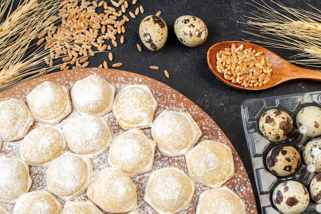 Kostenloses Foto draufsicht kleine teigstücke mit mehl auf dunklem hintergrund farbe kuchen kuchen hotcake teig knödel brötchen fleisch