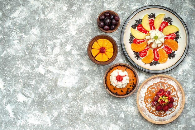 Draufsicht kleiner cremiger Kuchen mit Himbeerkuchen und Torte auf weißer Oberfläche Obst süßer Kekskuchen Kuchen Zucker