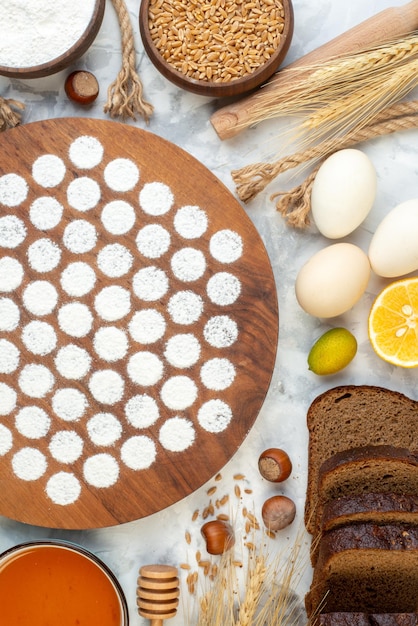 Draufsicht kleiner runder Teig um Eier Geleemehl und dunkles Brot auf dem weißen Hintergrund backen Ofenkuchen Kuchen Farbe Eiermilch Frühstück