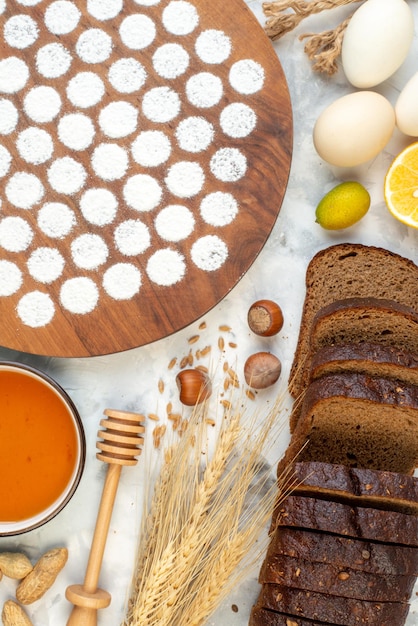 Draufsicht kleiner runder Teig um Eier Geleemehl und dunkles Brot auf dem weißen Hintergrund backen Ofenkuchen Kuchen Farbe Eiermilch Frühstück