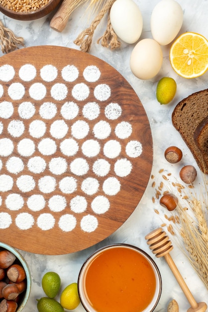 Draufsicht kleiner runder Teig um Eier Geleemehl und dunkles Brot auf weißem Hintergrund backen Ofenkuchen Kuchen Farben Eiermilch Frühstück