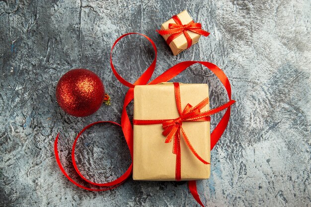 Draufsicht kleines Geschenk mit rotem Band Weihnachtskugel auf dunklem Hintergrund gebunden