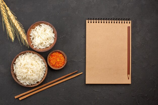 Draufsicht köstlich gekochter Reis einfache leckere Mahlzeit im Teller auf dem dunklen Raum