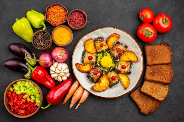 Draufsicht köstliche Auberginenröllchen mit Kartoffeln und frischem Gemüse auf dunklem Hintergrundgericht Abendessen reifes Essen