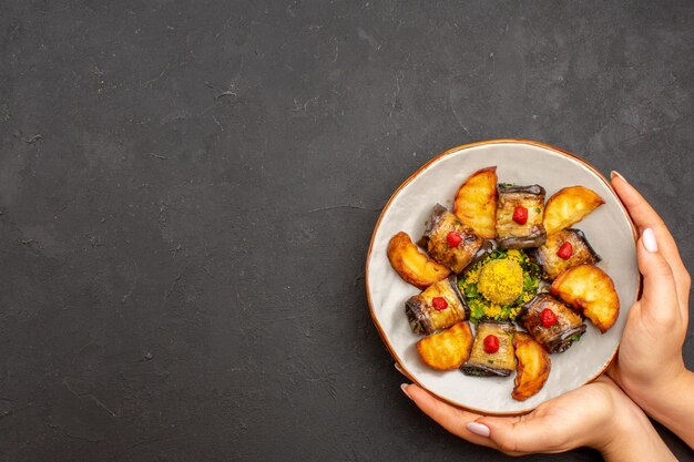 Draufsicht köstliche Auberginenrollen gekochtes Gericht mit Ofenkartoffeln auf dem dunklen Hintergrund Kartoffelgericht Mahlzeit Abendessen Essen kochen food