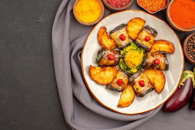 Draufsicht köstliche Auberginenrollen gekochtes Gericht mit Ofenkartoffeln und Gewürzen auf dem dunklen Hintergrund
