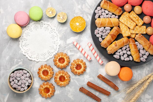 Draufsicht köstliche Bagels mit Crackern Macarons und Kekse auf weißem Schreibtischkuchenkeks süßer Zuckerkuchenplätzchen knusprig