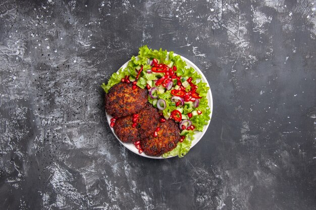 Draufsicht köstliche Fleischkoteletts mit frischem Salat