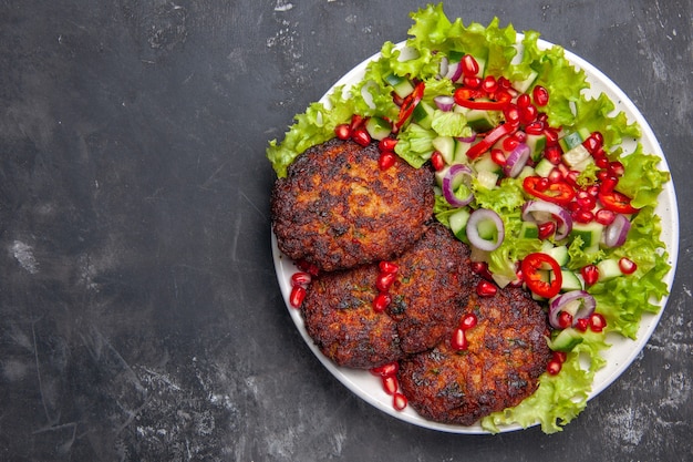 Draufsicht köstliche Fleischkoteletts mit frischem Salat