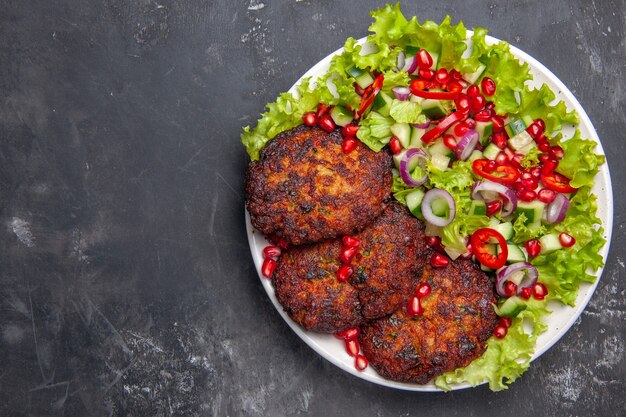 Draufsicht köstliche Fleischkoteletts mit frischem Salat