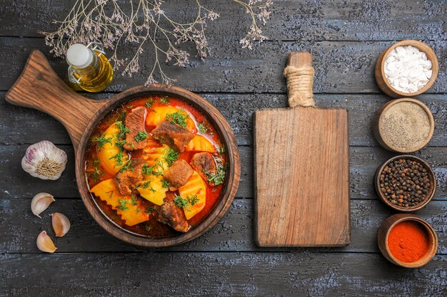 Draufsicht köstliche Fleischsuppe mit grünen Kartoffeln auf dem dunklen Schreibtisch