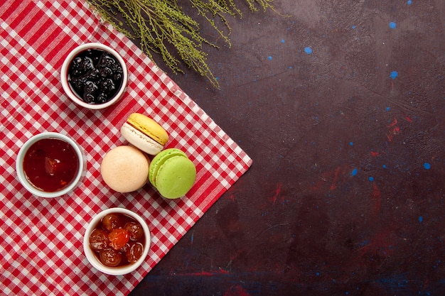 Draufsicht köstliche französische Macarons mit Fruchtmarmeladen auf dunklem Hintergrundmarmelade süßer Teekuchenkeks süß