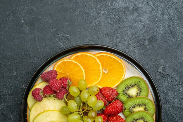 Draufsicht köstliche Fruchtzusammensetzung frisch geschnittene und ausgereifte Früchte auf dunklem Boden reife frische ausgereifte Gesundheitsdiät