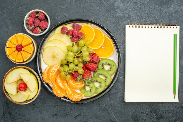 Draufsicht köstliche Fruchtzusammensetzung frisch geschnittene und ausgereifte Früchte auf dunklem Hintergrund reife frische Gesundheitsfrucht ausgereift