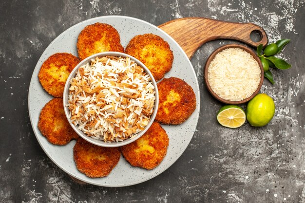 Draufsicht köstliche gebratene Schnitzel mit gekochtem Reis auf dunklem Oberflächengericht Frikadellenfleisch