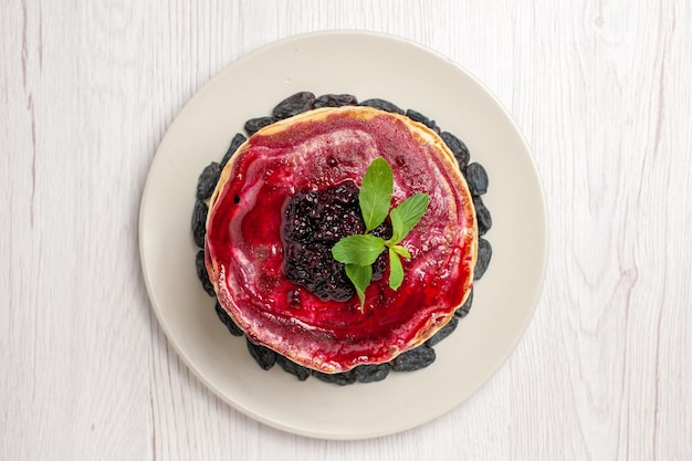 Draufsicht köstliche Geleepfannkuchen mit Rosinen und Fruchtgelee auf weißem Hintergrund Kuchen Keks Dessert Gelee Marmelade süß