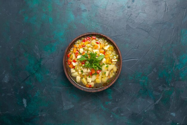 Draufsicht köstliche Gemüsesuppe mit geschnittenem Gemüse und Gemüse auf dunkelblauem Hintergrundsuppe Gemüsemahlzeitmahlzeitmahlzeitsauce