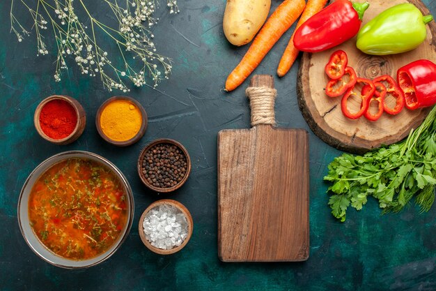 Draufsicht köstliche Gemüsesuppe mit Gewürzen auf grüner Oberfläche Lebensmittelgemüsesuppe Suppenprodukt Mahlzeit