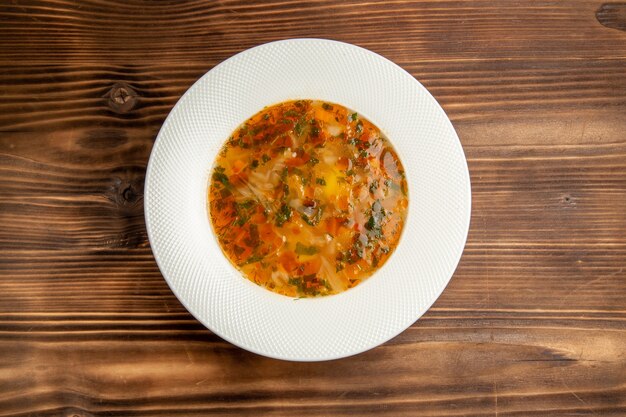 Draufsicht köstliche Gemüsesuppe mit Grün auf braunem Holztischsuppenlebensmittelgemüsemehlgewürz