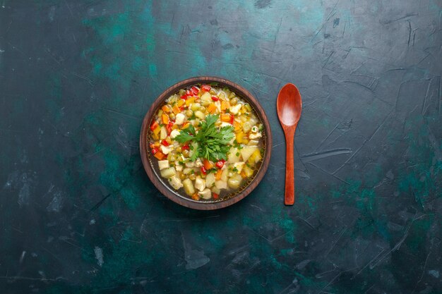 Draufsicht köstliche Gemüsesuppe mit verschiedenen Bestandteilen innerhalb der braunen Platte auf der dunklen Schreibtischsuppe Gemüsesauce Mahlzeit Essen warmes Essen Gericht