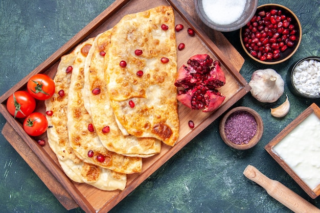 Kostenloses Foto draufsicht köstliche gutabs dünne heiße kuchen mit fleisch im schreibtisch auf der dunklen oberfläche