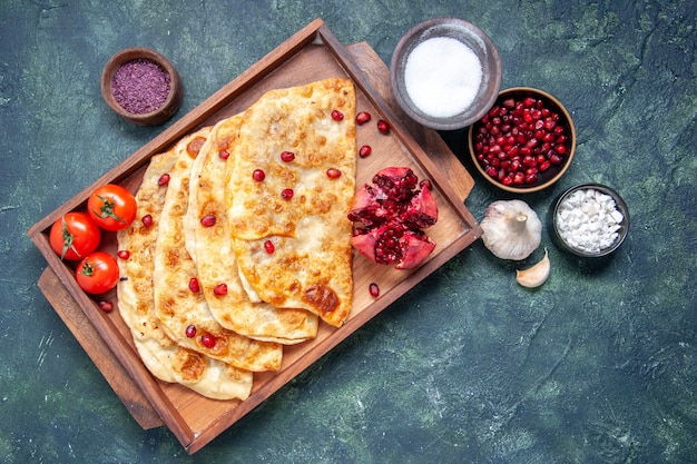 Kostenloses Foto draufsicht köstliche gutabs dünne heiße kuchen mit fleisch im schreibtisch auf der dunklen oberfläche