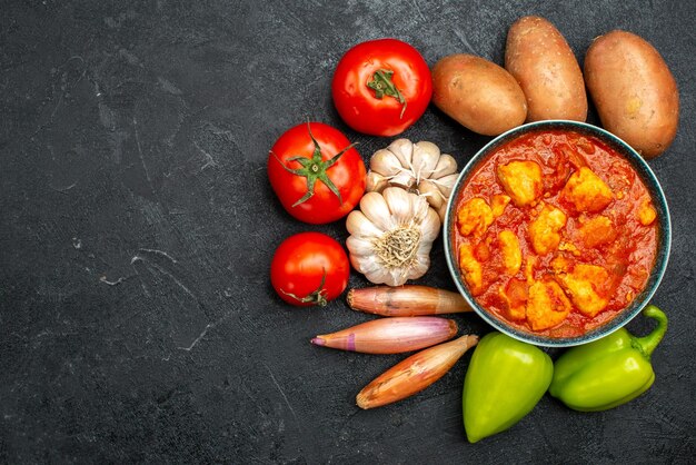 Draufsicht köstliche Hähnchenscheiben mit Tomatensauce und Gemüse auf dunkelgrauem Hintergrund Saucengericht Hühnchen-Tomaten-Fleisch