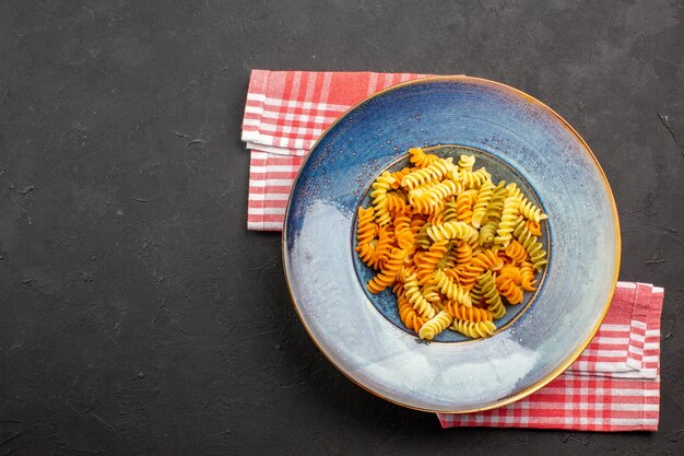 Draufsicht köstliche italienische Pasta ungewöhnliche gekochte Spiralnudeln auf dem dunklen Hintergrund Nudelgericht Mahlzeit kochen Abendessen
