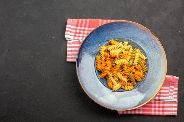 Draufsicht köstliche italienische Pasta ungewöhnliche gekochte Spiralnudeln auf dem dunklen Hintergrund Nudelgericht Mahlzeit kochen Abendessen