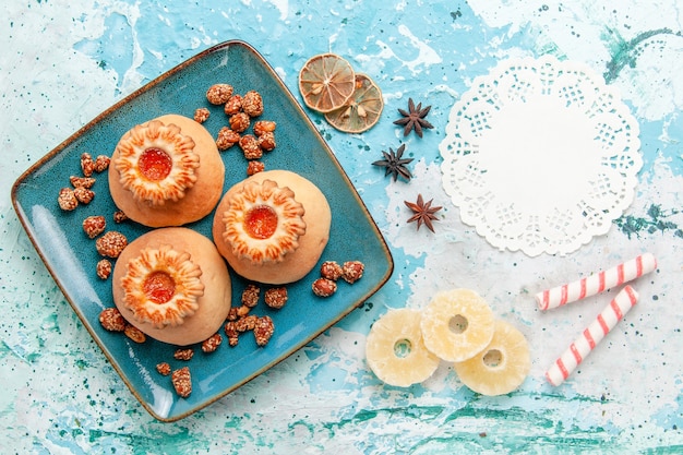 Draufsicht köstliche Kekse mit Bonbons auf der hellblauen Hintergrundplätzchenkeks-süßen Zuckerfarbe