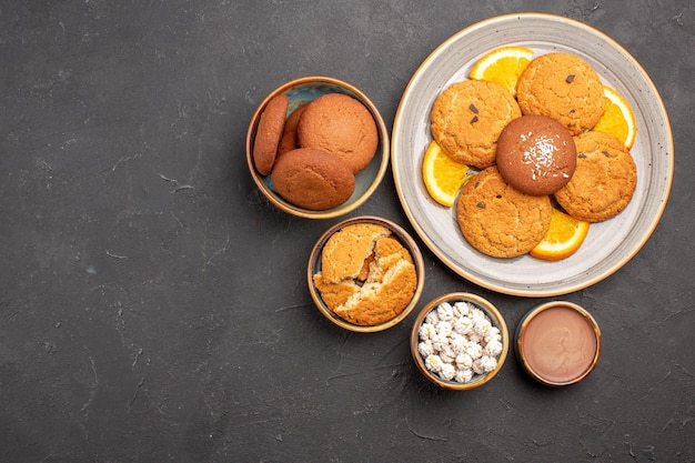 Draufsicht köstliche kekse mit frisch geschnittenen orangen auf dunklem hintergrund keksfrucht süßer kuchen keks zitrus