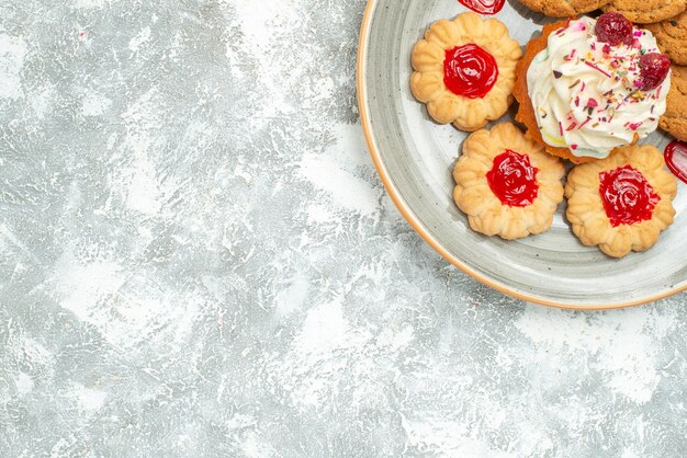 Draufsicht köstliche Kekse mit Keksen und Sahnetorte auf dem weißen Hintergrund süßer Teekeksplätzchen-Zuckerkuchen