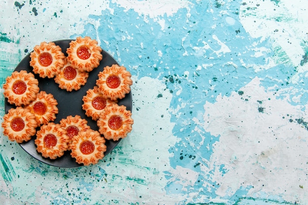 Kostenloses Foto draufsicht köstliche kekse mit marmelade in schwarzer platte auf blauem hintergrundplätzchenkeks süßer zuckerfarbentee