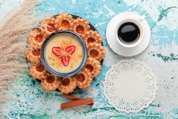 Draufsicht köstliche kekse mit marmelade tasse kaffee und erdbeerdessert auf der blauen oberfläche