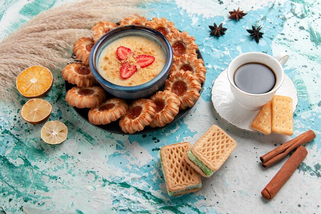 Draufsicht köstliche Kekse mit Marmelade Tasse Kaffee und Erdbeerdessert auf hellblauer Oberfläche