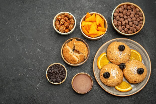 Draufsicht köstliche Kekse mit Nüssen und Orangenscheiben auf dunkelgrauem Hintergrund Kekse Keks Tee süßer Kuchen