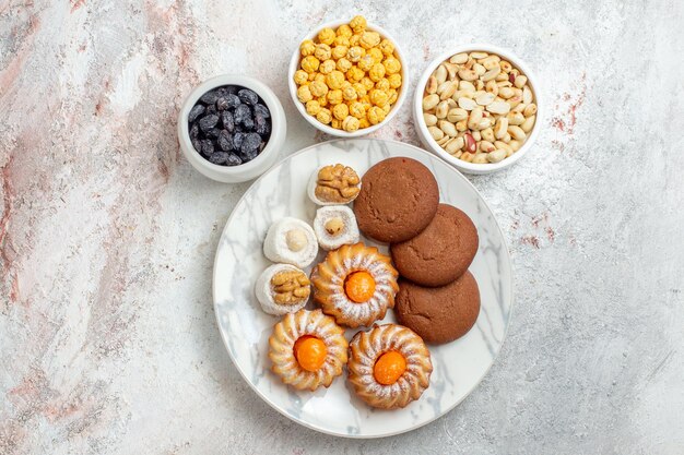 Draufsicht köstliche Kekse mit Süßigkeiten und Nüssen auf weißem Hintergrund Keks süße Kuchen Keksnuss