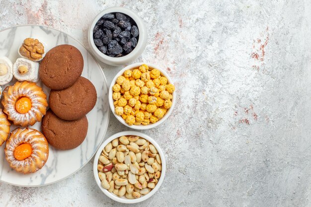 Draufsicht köstliche Kekse mit Süßigkeiten und Nüssen auf weißem Hintergrund süßer Kuchen Keks Keks Zuckertee