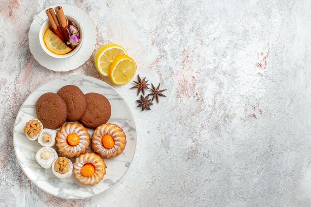 Draufsicht köstliche Kekse mit Tasse Tee auf weißem Hintergrund Keks Keks Zucker süßer Kuchen Tee