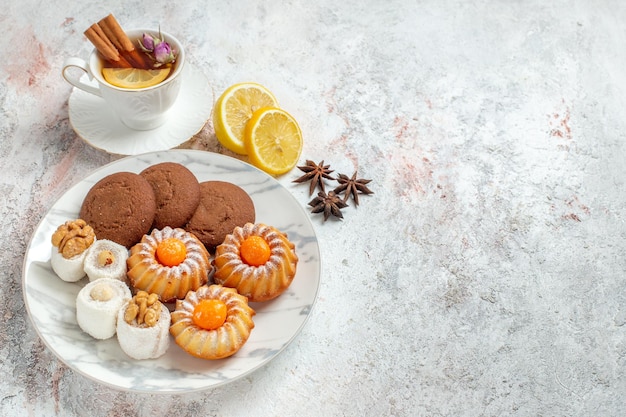 Draufsicht köstliche Kekse mit Tasse Tee auf weißem Hintergrund Keks Keks Zucker süßer Kuchen Tee