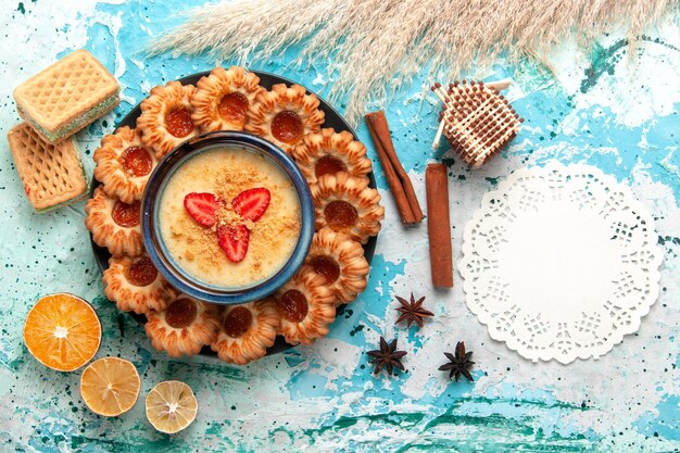 Draufsicht köstliche Kekse mit Waffeln und Erdbeerdessert auf blauem Schreibtisch