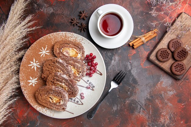 Draufsicht köstliche Keksröllchen mit Keksen auf dunklem Tisch süße Kuchenkuchen