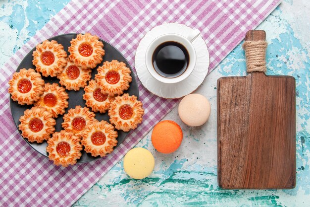 Draufsicht köstliche kleine Kekse mit französischen Macarons und Kaffee auf blauem Hintergrundplätzchenkeks süßer Zuckerfarbentee