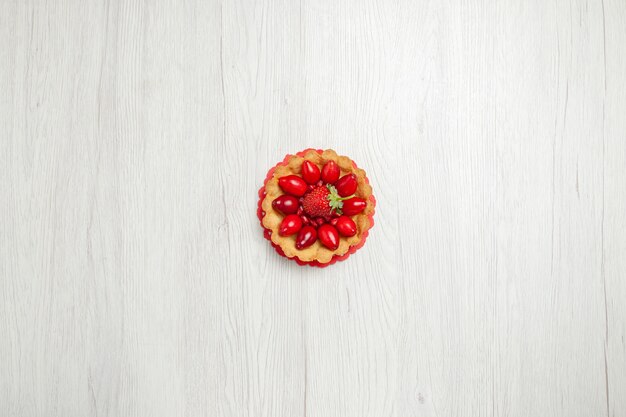 Draufsicht köstliche kleine Kuchen mit Früchten auf weißem Schreibtisch