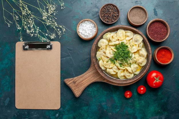 Draufsicht köstliche Knödelsuppe mit Gewürzen auf grüner Schreibtischnahrung Fleischgemüseteig-Suppe