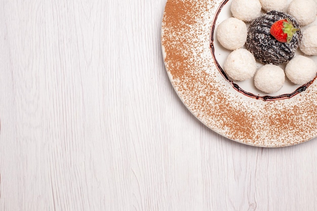 Draufsicht köstliche Kokos-Bonbons mit Schokoladenkuchen auf weißem Hintergrund Zuckerkuchen Keks süße Süßigkeiten Kekse