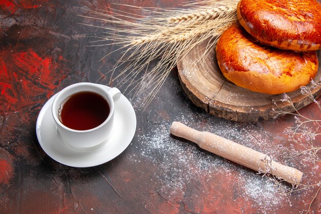 Draufsicht köstliche Kuchen für Tasse Tee auf dem dunklen Tisch