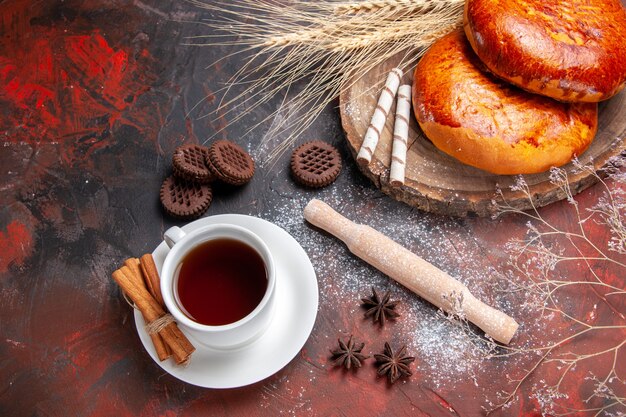 Draufsicht köstliche Kuchen für Tasse Tee auf dem dunklen Tisch