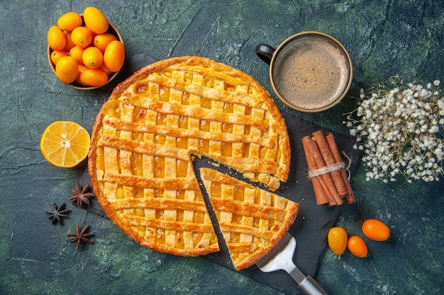 Draufsicht köstliche Kumquat-Torte mit geschnittenem Stück und Kaffee auf dunklem Hintergrund