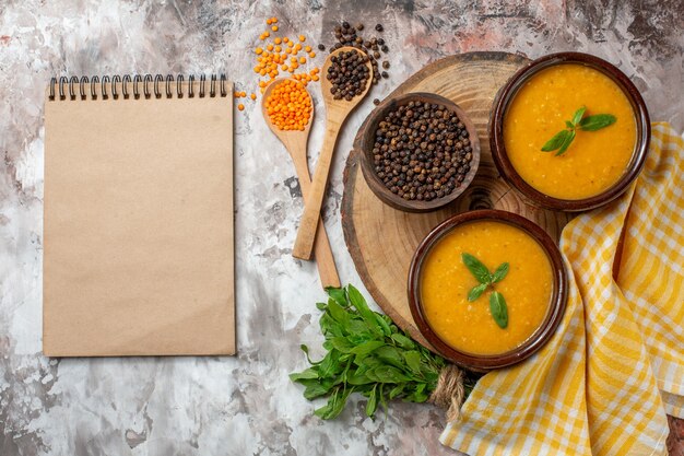 Draufsicht köstliche Linsensuppe in Tellern auf der hellen Oberfläche Farbe Samen Pflanzensuppe Essen Gericht Foto Brot heiß